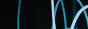 Abstrakte leuchtende blaue Kabel vor schwarzem Hintergrund