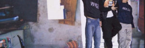 Bild aus dem Stück Arab Boy. Drei Schauspieler lehnen an einer Wand und schauen sich gegenseitig an
