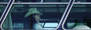 Eine Person mit Cowboyhut sitzt in einem Bus.